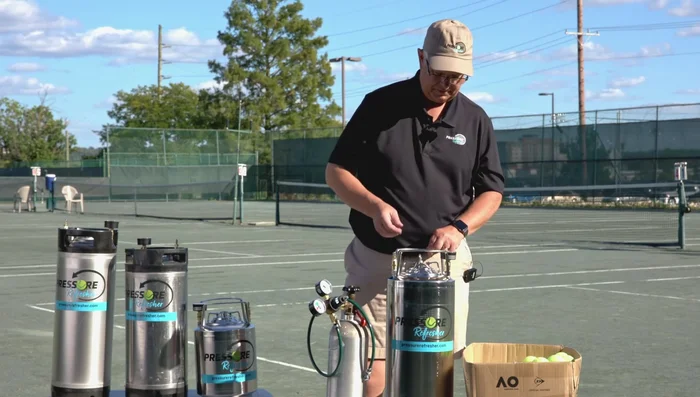 Release pressure and retrieve: Release pressure by pulling up and turning the pressure release pin 90 degrees. Open the keg and remove the repressurized tennis balls.