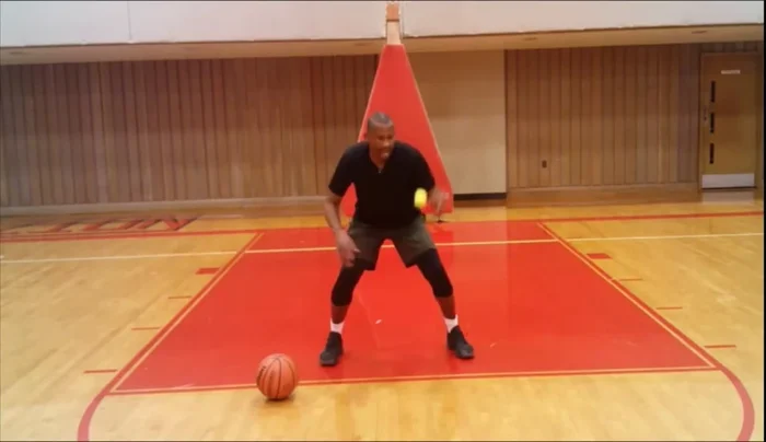 Repeat the toss and snatch 10 times on each side, focusing on keeping your palm to the ground when catching the ball to maintain a low center of gravity and evade defenders.