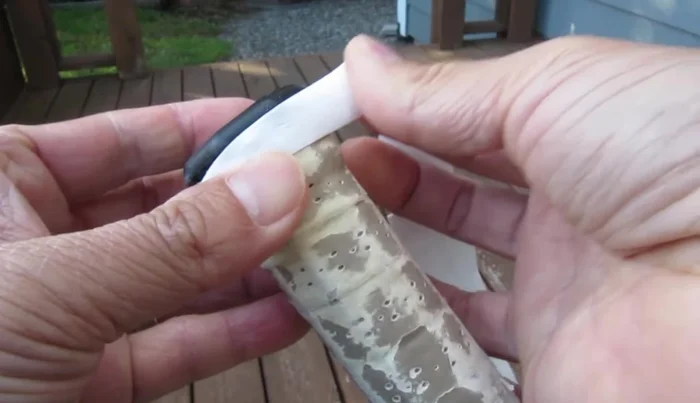 Begin wrapping the overgrip counter-clockwise around the handle, maintaining constant tension and slightly stretching the material.