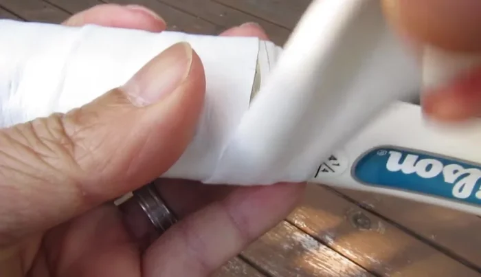 Once the overgrip reaches the end of the handle, overlap it with the existing tape, make a mark where the tape begins and another where the final overlap ends.