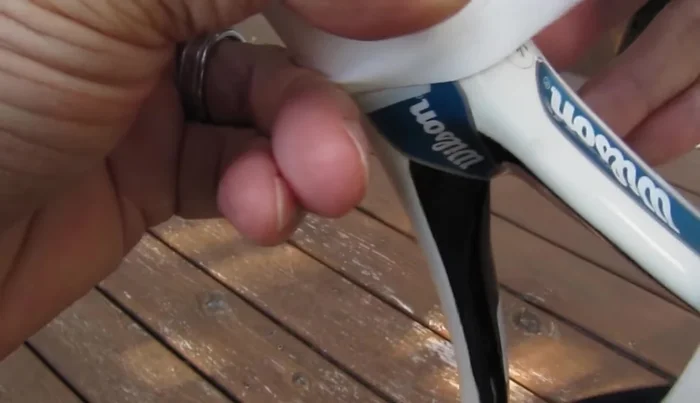 Use the finishing tape to secure the cut end of the overgrip to the handle.