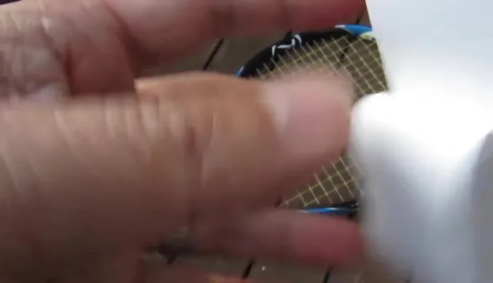 Peel off the protective plastic layer from the sticky end of the overgrip.