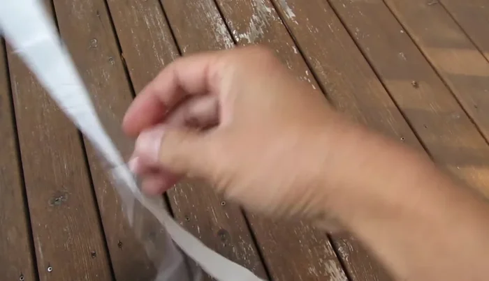 Peel off the protective plastic layer from the sticky end of the overgrip.