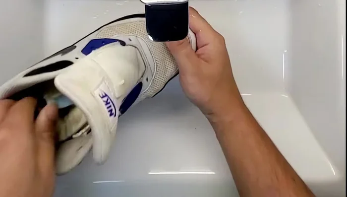 Use a toothbrush to scrub the mesh in a circular motion, then focus on dirtier areas. Continue brushing until you see suds form.