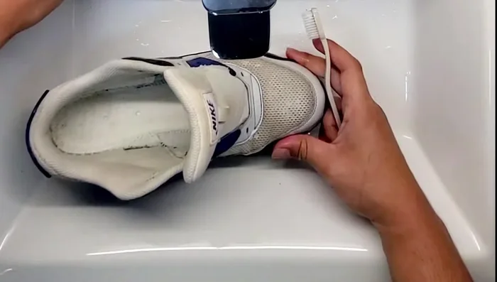 Use a toothbrush to scrub the mesh in a circular motion, then focus on dirtier areas. Continue brushing until you see suds form.