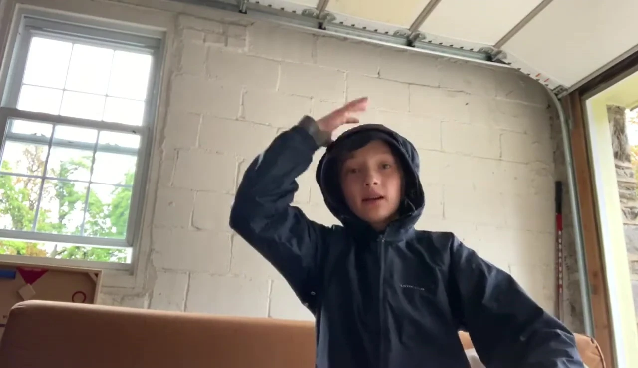 The YouTuber wearing a raincoat, indicating the inclement weather.