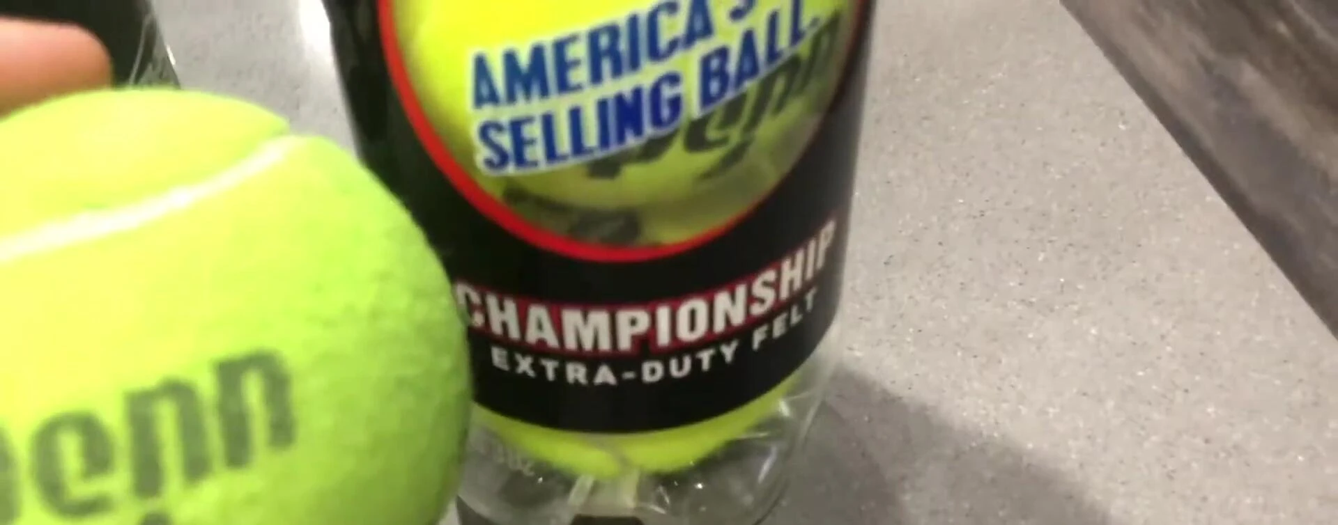 Comparison of a new and used Penn Championship tennis ball, highlighting the dirt accumulation.