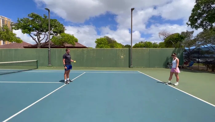 Get in a ready position behind the baseline, bouncing up and down.