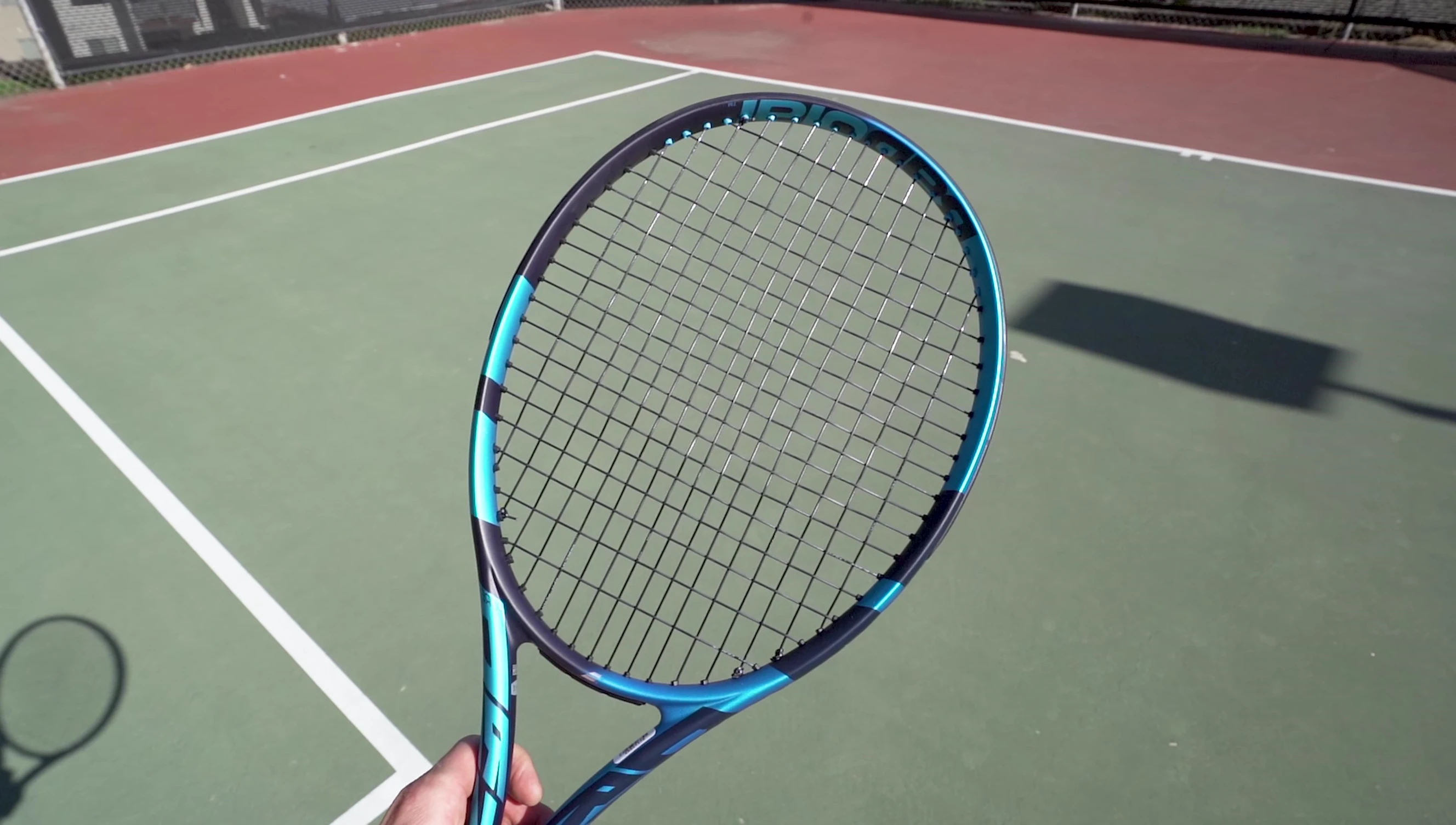 The reviewer showing how the strings stay put after hitting a ball.