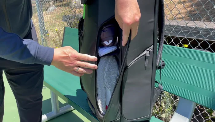Demonstrating the straps and the bag's ability to be attached to fences.