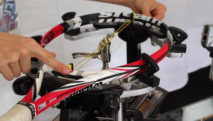 Apply initial tension using the stringing machine (adjust tension as needed). Clamp the opposite end after pulling the string tight.