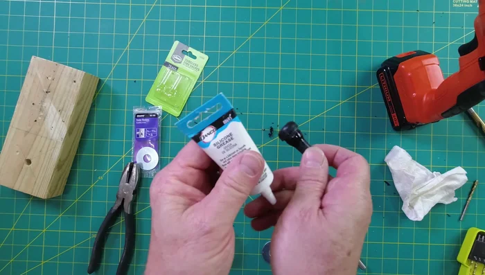 Secure the valve and washer by screwing on the plastic piece from inside the container.