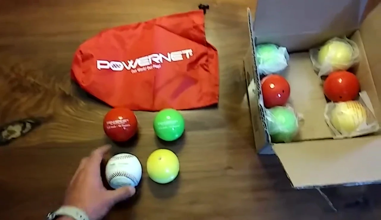 A comparison shot of a regulation baseball and the PowerNet weighted hitting balls showcasing the size difference.