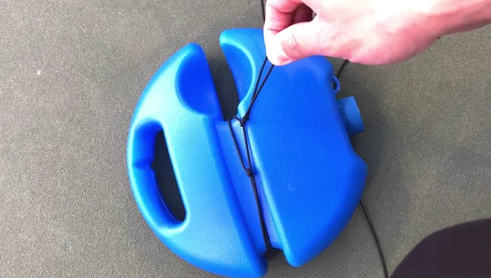 Tie the string of the tennis ball in the middle, not at the top as shown in previous videos. Ensure it's tied securely to prevent it from flying off.