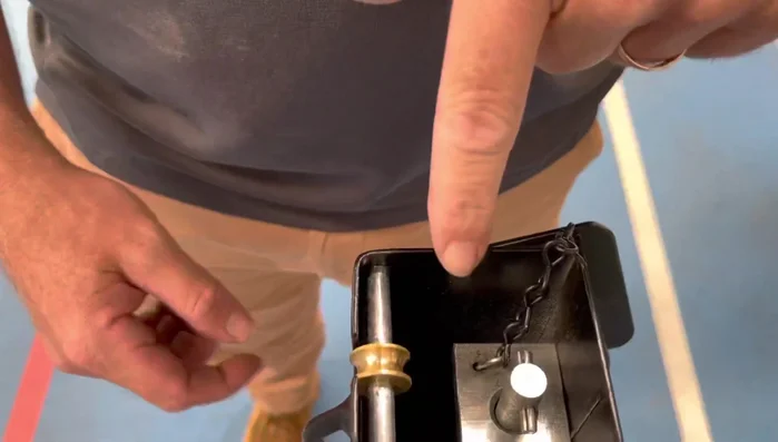 Grab the cable and attach it to the little wheel guide on the winder mechanism.