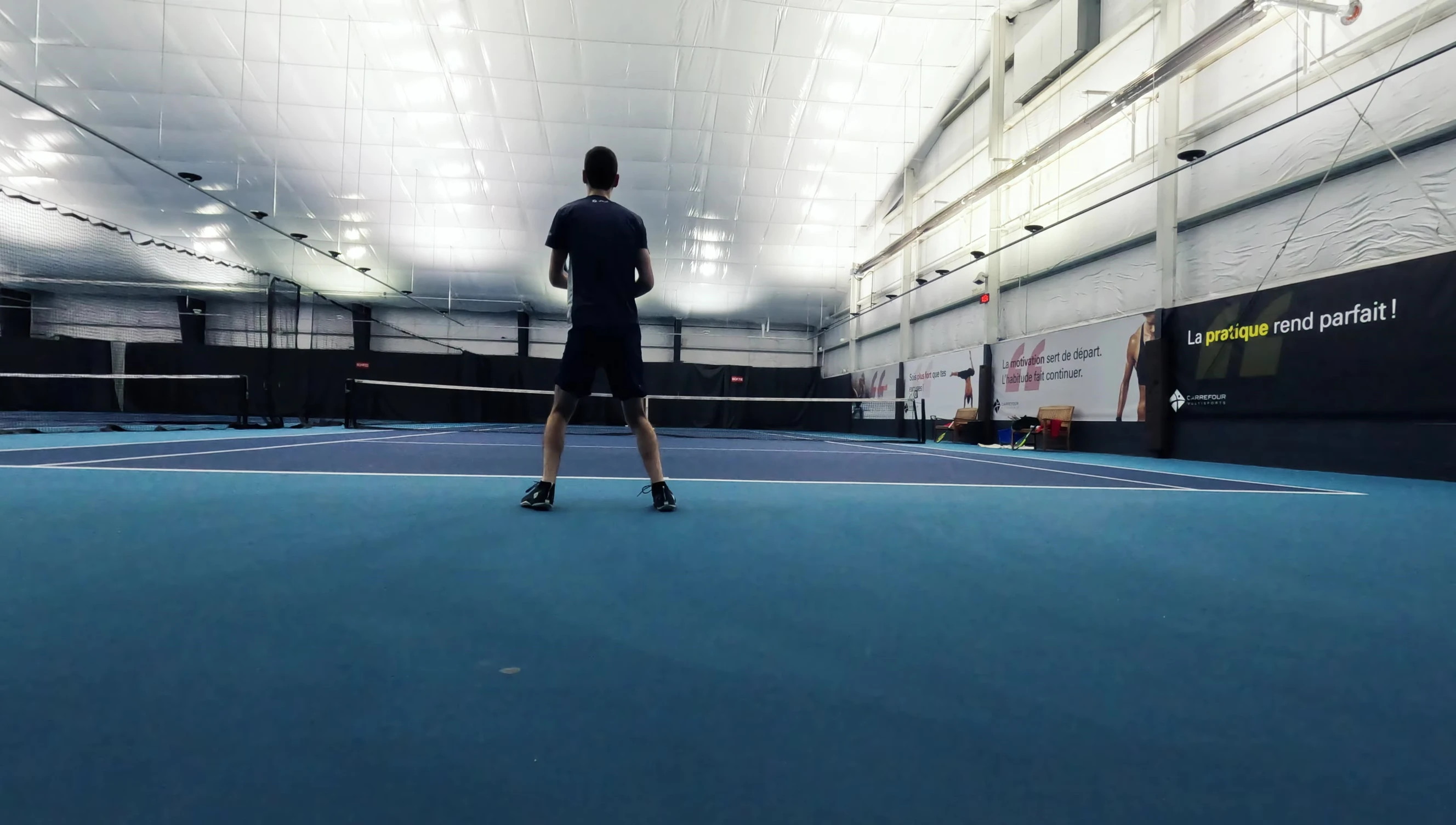 The reviewer holding the racket on the tennis court.