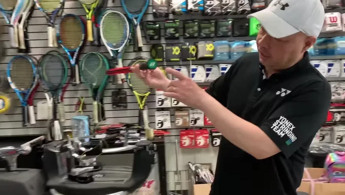 Secure the racket using fingertip pressure on the clamps. Ensure 12 o'clock and 6 o'clock positions are aligned.