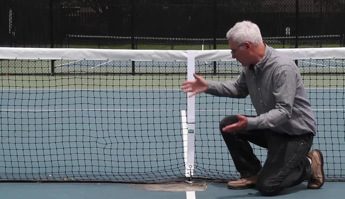 Reinstall the center strap, adjusting the tension to achieve the correct net height.