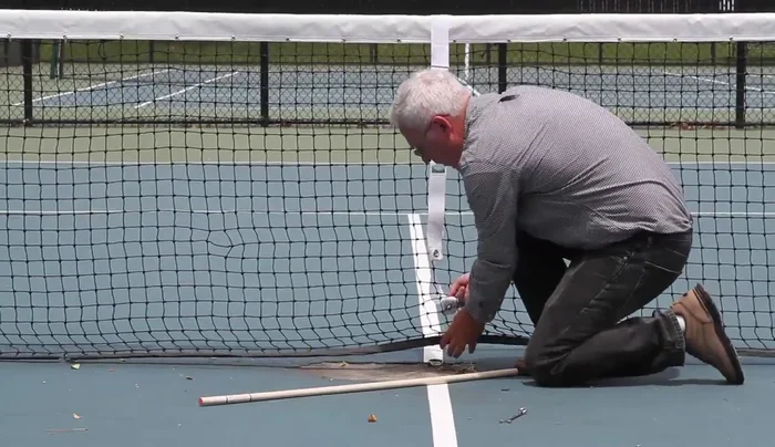 Reinstall the center strap, adjusting the tension to achieve the correct net height.