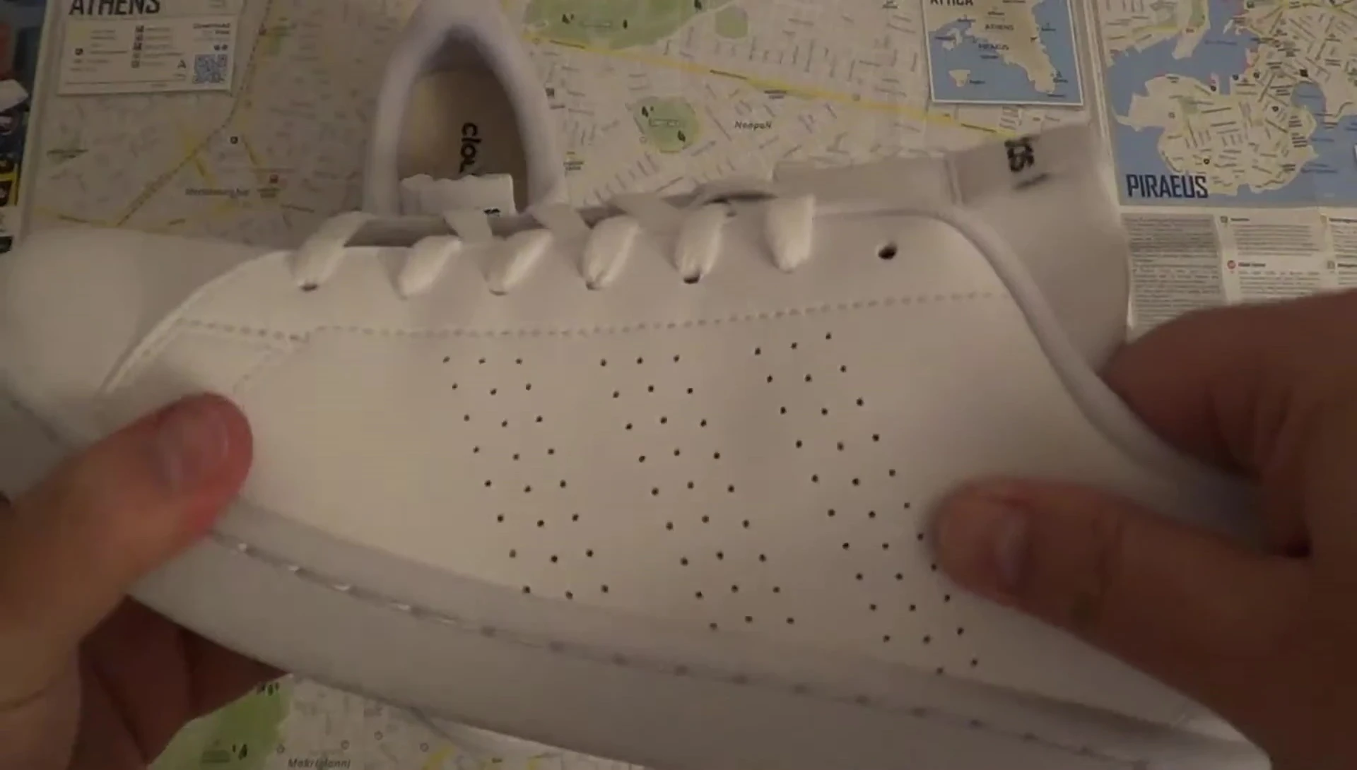 A close-up of the left shoe showcasing the material and three stripes